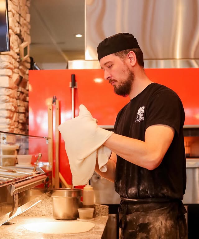 Hand-stretching apizza dough at Industry Apizza